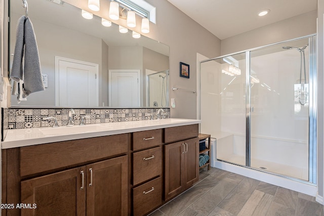 bathroom featuring backsplash, vanity, and a shower with shower door