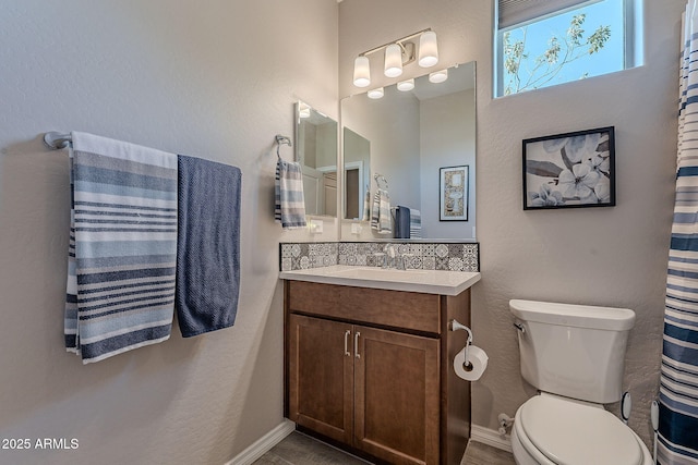 bathroom featuring decorative backsplash, toilet, and vanity