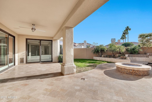 view of patio with ceiling fan and an outdoor fire pit