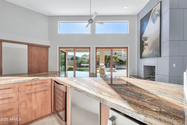 kitchen with light stone countertops, a wealth of natural light, and wine cooler