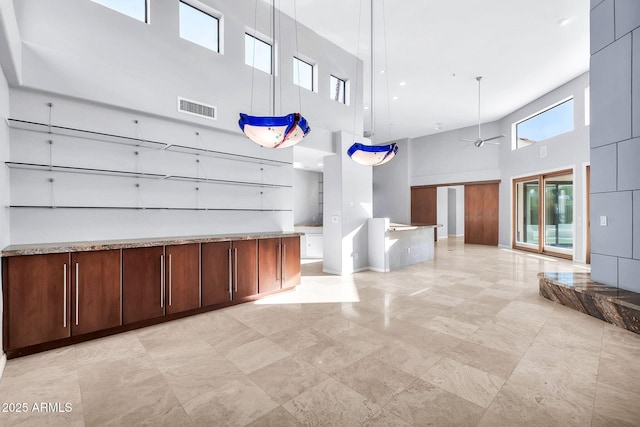 miscellaneous room featuring a towering ceiling and ceiling fan