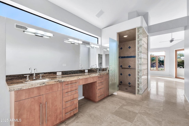 bathroom featuring ceiling fan, tiled shower, and vanity