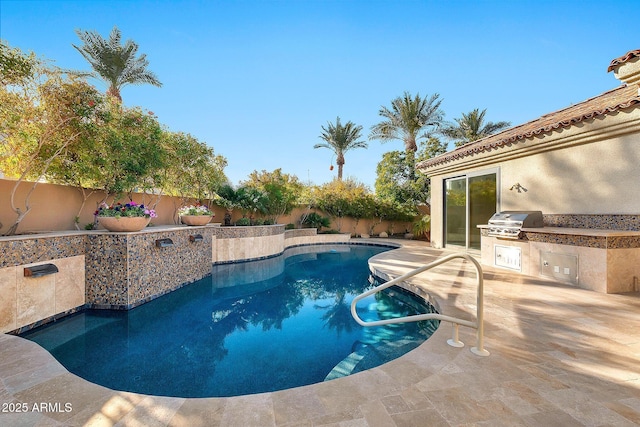 view of swimming pool featuring exterior kitchen, a patio, and grilling area