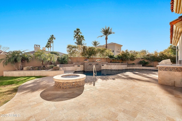 view of patio / terrace featuring an outdoor kitchen and an outdoor fire pit