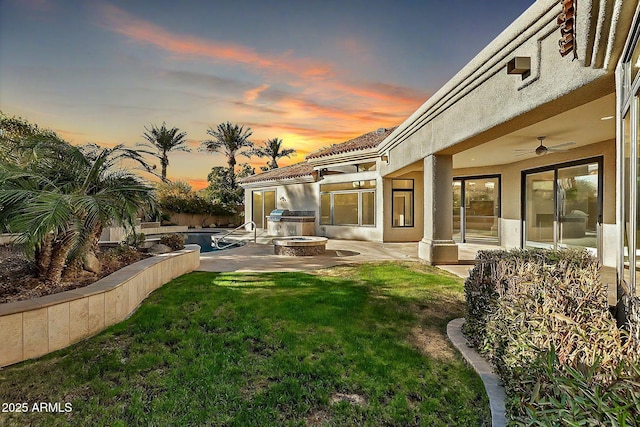 yard at dusk featuring a fenced in pool, a patio, and ceiling fan