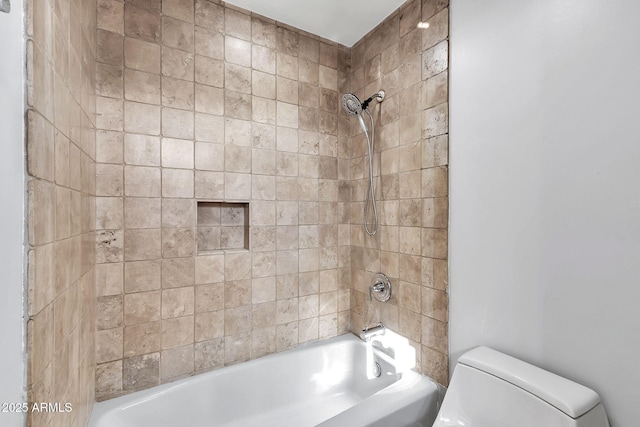 bathroom with toilet and tiled shower / bath combo