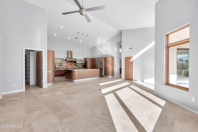 unfurnished living room featuring sink, high vaulted ceiling, and ceiling fan