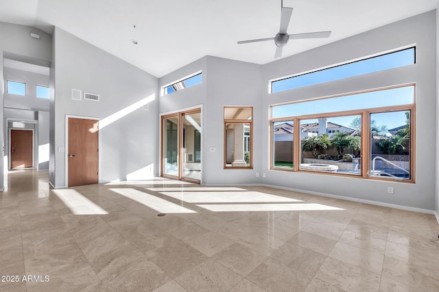 unfurnished living room featuring a towering ceiling and ceiling fan