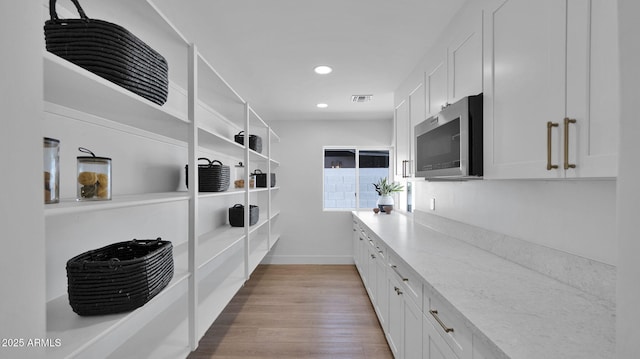 5109 E Blanche Dr, Scottsdale, AZ 85254 - kitchen featuring stainless steel microwave, white cabinets, light stone countertops, baseboards, and recessed lighting