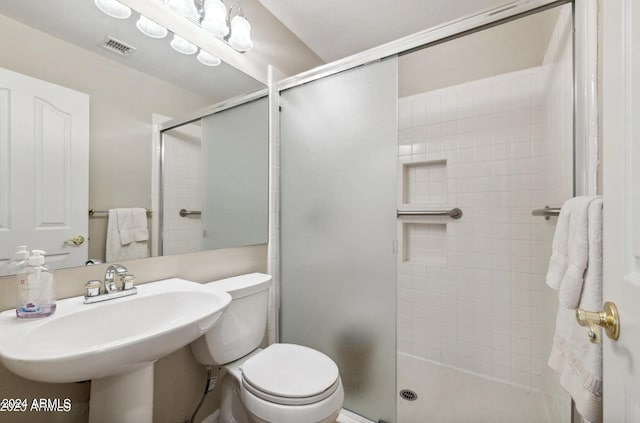 bathroom featuring sink, walk in shower, and toilet