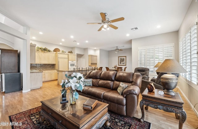 living room with light wood-type flooring and ceiling fan