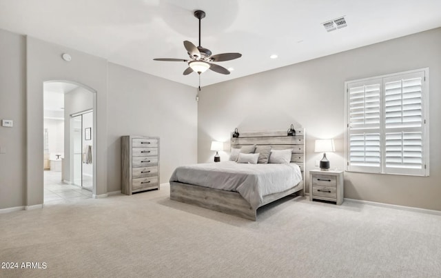 carpeted bedroom with ceiling fan and ensuite bath