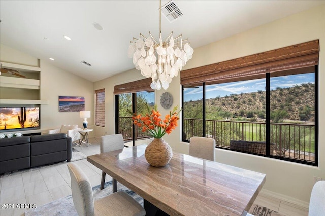 dining area with vaulted ceiling and an inviting chandelier