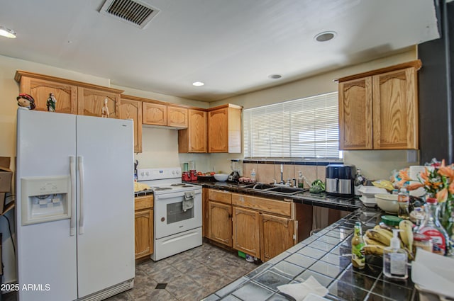 kitchen with recessed lighting, white appliances, a sink, visible vents, and tile counters