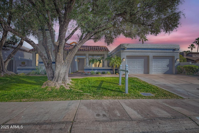 view of front of house with a garage and a yard