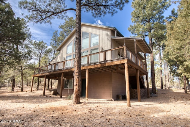 rear view of property featuring a wooden deck