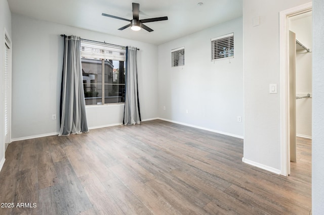 unfurnished room featuring ceiling fan, baseboards, and wood finished floors