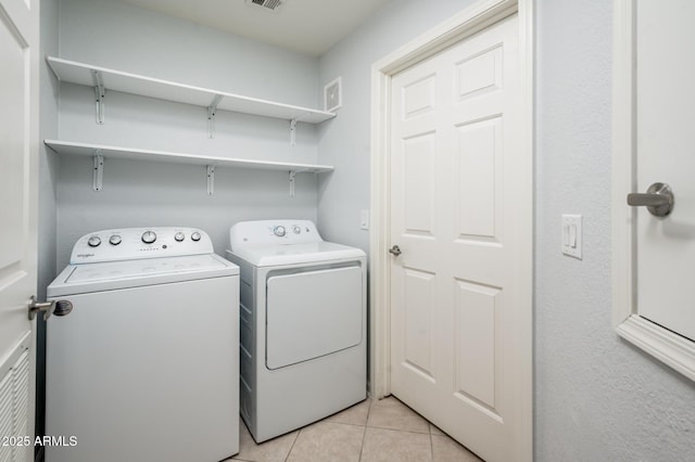 laundry area with laundry area, light tile patterned flooring, visible vents, and washer and dryer