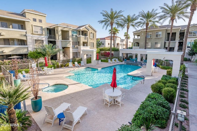 community pool with a residential view, fence, a community hot tub, and a patio