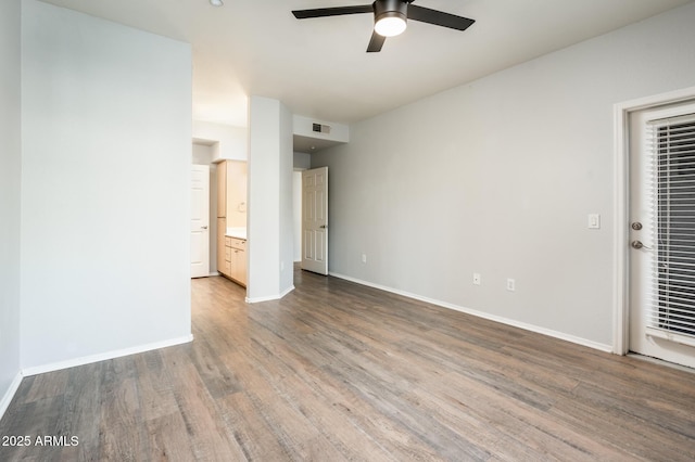 unfurnished bedroom featuring baseboards, connected bathroom, visible vents, and wood finished floors