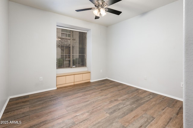 empty room featuring ceiling fan, baseboards, and wood finished floors