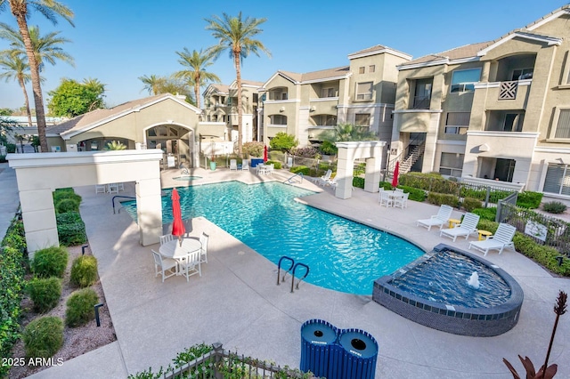 pool with a patio area, fence, and a residential view