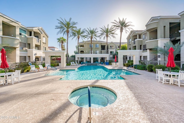 community pool featuring a patio area, fence, and a community hot tub