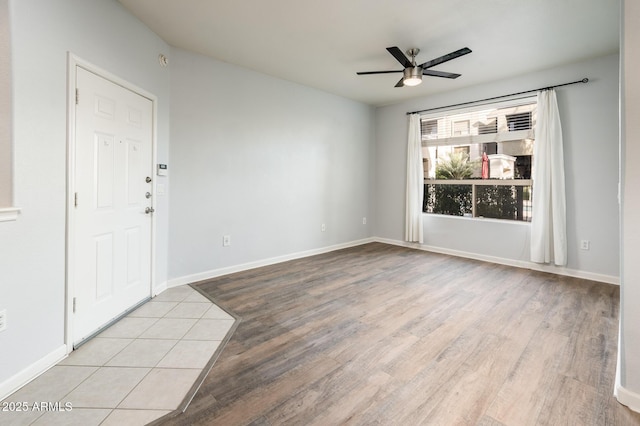 unfurnished room with ceiling fan, baseboards, and wood finished floors