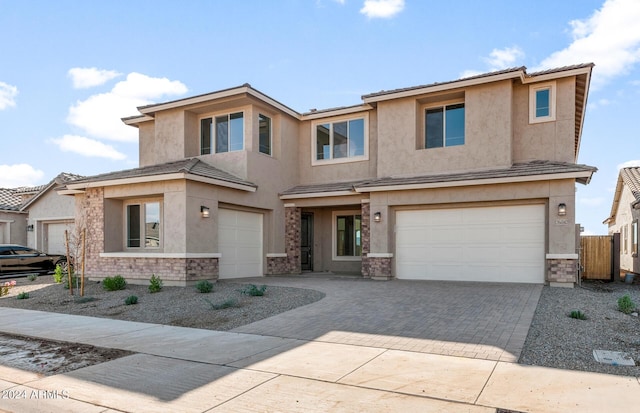 view of front of property with stucco siding, driveway, and an attached garage