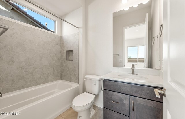 full bathroom with tiled shower / bath, vanity, toilet, and a wealth of natural light