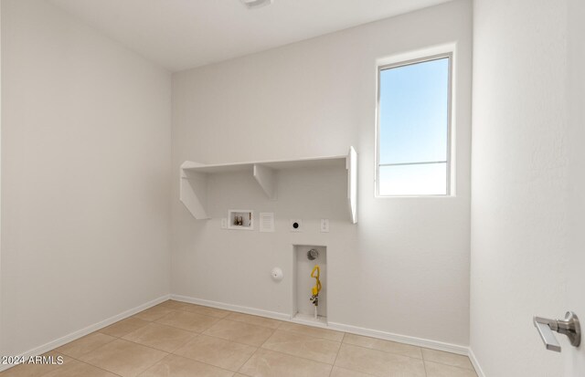 washroom with light tile patterned floors, hookup for a washing machine, hookup for a gas dryer, and a wealth of natural light