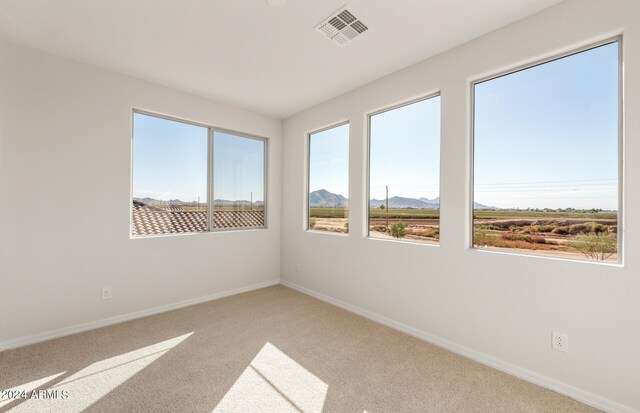 empty room with carpet flooring and a mountain view