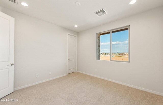 unfurnished room featuring light carpet