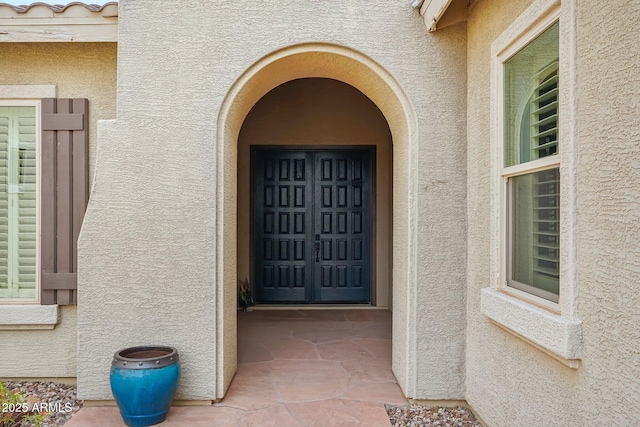 entrance to property featuring stucco siding