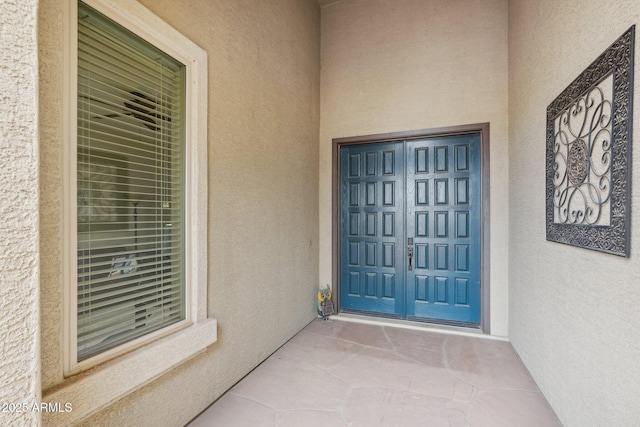 view of exterior entry featuring stucco siding