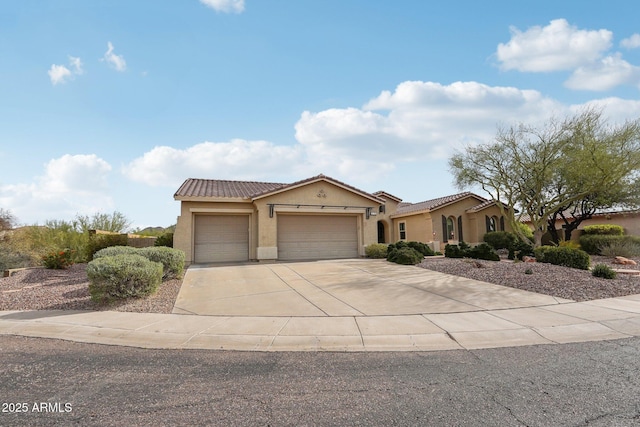 mediterranean / spanish home featuring stucco siding, a tile roof, a garage, and driveway