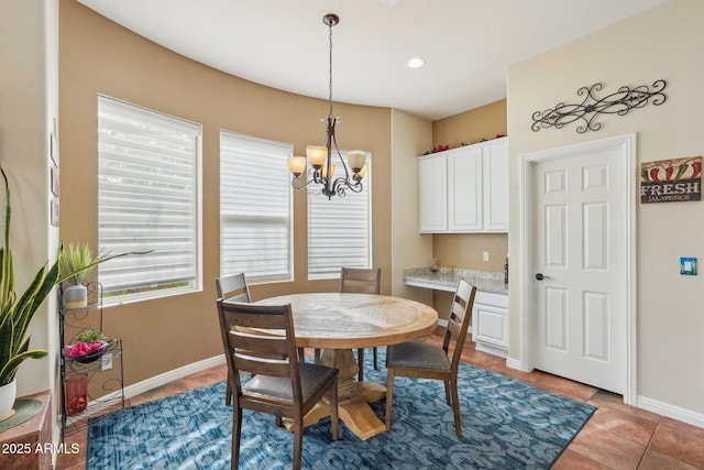 dining space with light tile patterned floors, a notable chandelier, and baseboards
