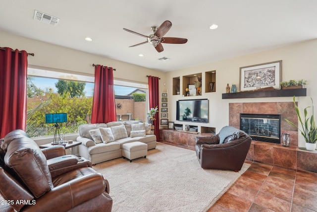 living room featuring a premium fireplace, recessed lighting, ceiling fan, and visible vents