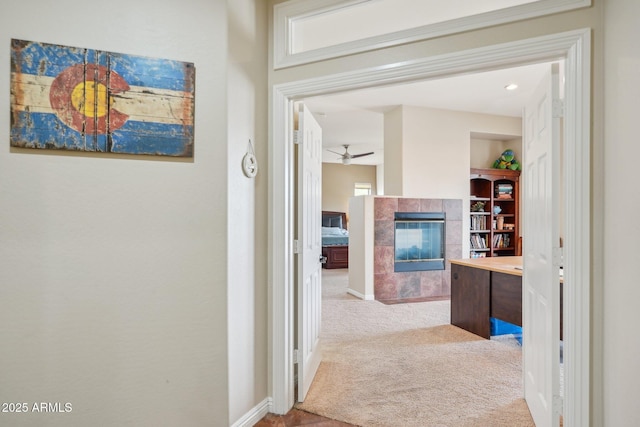 hallway featuring carpet flooring and baseboards