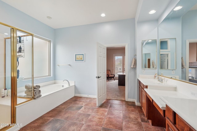 bathroom featuring double vanity, baseboards, a bath, and a sink