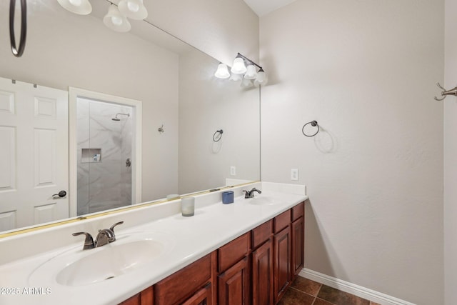 full bathroom with baseboards, double vanity, a sink, and a walk in shower