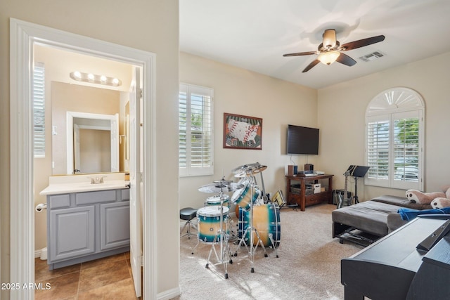 interior space with carpet floors, visible vents, a ceiling fan, and plenty of natural light