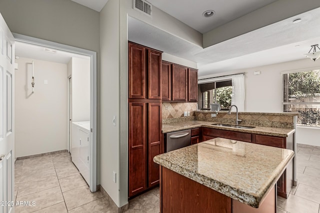 9550 E Thunderbird Rd Unit 149, Scottsdale, AZ 85260 - kitchen featuring a peninsula, a sink, tasteful backsplash, visible vents, and separate washer and dryer