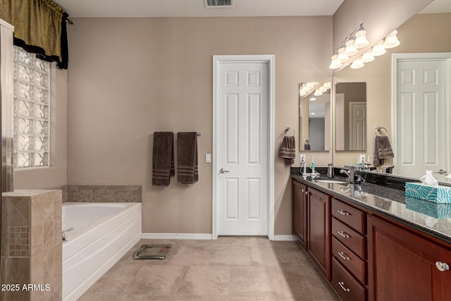 bathroom with vanity, a bath, and tile patterned floors