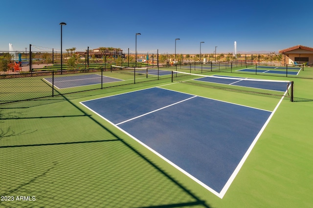 view of tennis court with community basketball court and fence