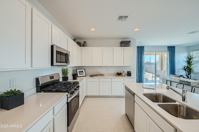 kitchen with a sink, visible vents, appliances with stainless steel finishes, and white cabinets