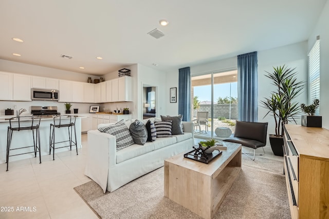 living room with light tile patterned floors, recessed lighting, and visible vents