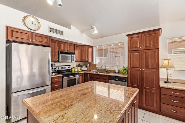 4441 E Desert Wind Dr, Phoenix, AZ 85044 - kitchen featuring stainless steel appliances, lofted ceiling, a sink, light stone counters, and a kitchen island