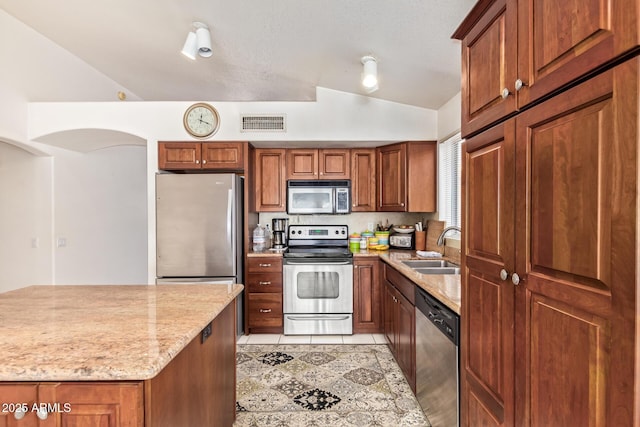 4441 E Desert Wind Dr, Phoenix, AZ 85044 - kitchen featuring appliances with stainless steel finishes, a sink, lofted ceiling, light tile patterned flooring, and light stone countertops