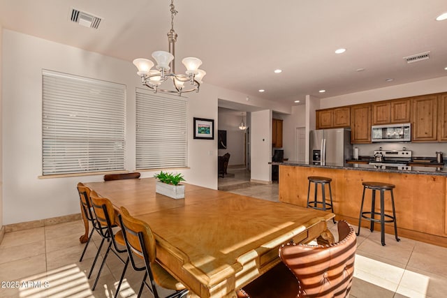 tiled dining room with a notable chandelier